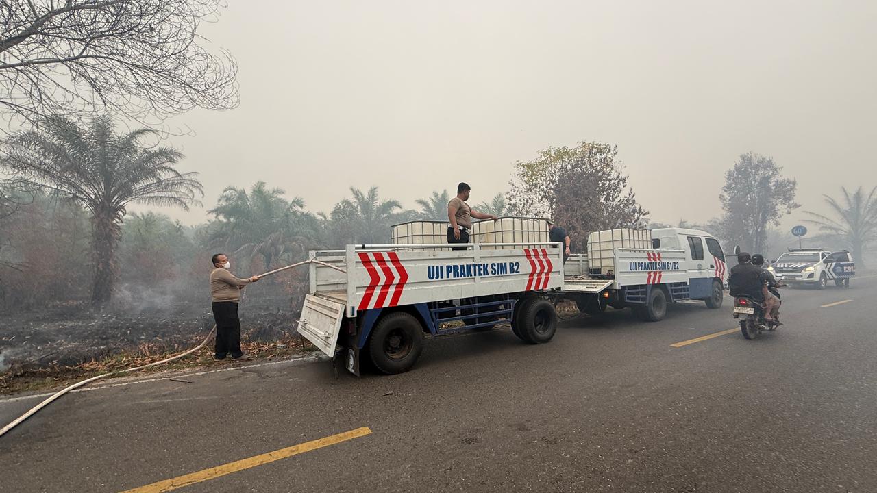 Personel Ditlantas Polda Kalteng Terjang Asap, Padamkan Karhutla di Jalan Mahir Mahar